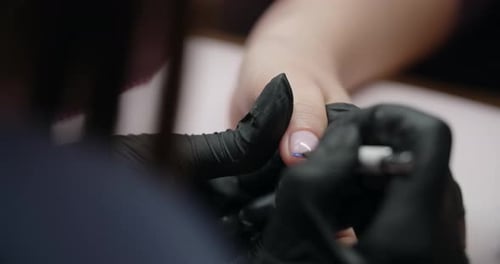 Manicurist Applies Blue Polish to Fingernail in Salon