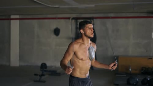 Fit Young Man Jumping Rope in Gym