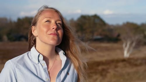 Fotógrafa sorrindo enquanto olha ao redor para a próxima foto