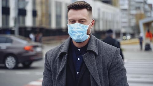 Homem durante a pandemia do vírus covid19. Jovem com máscara protetora na rua