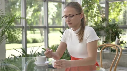 Woman Puts Earbuds In, Uses Phone Indoors