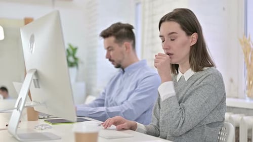 Creative Woman Working on Desktop and Coughing in Office