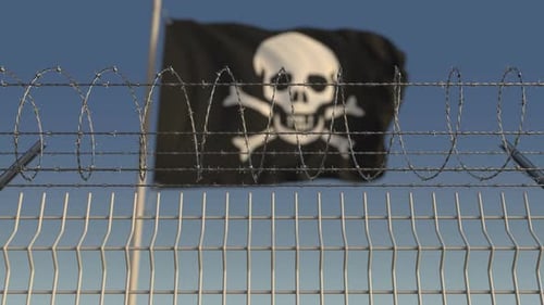 Pirate Flag Waving Behind Barbed Wire Fence