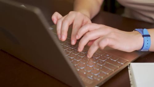 Hands Typing on Laptop Keyboard in Office