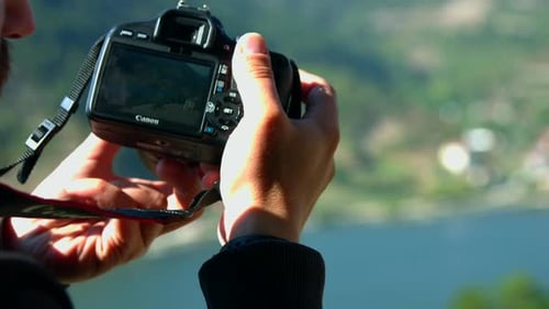 Man Photographs Lake and Mountains