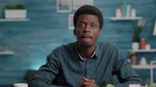 Young Adult Speaking at Desk During Video Call