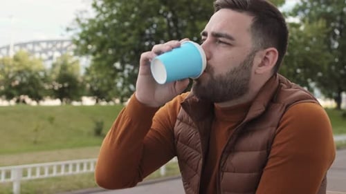 Man Drinking Coffee near Park