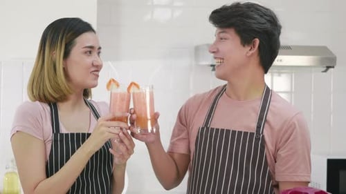pareja de familia marido y mujer disfrutando bebiendo jugo de batido de manzana fresco en la cocina