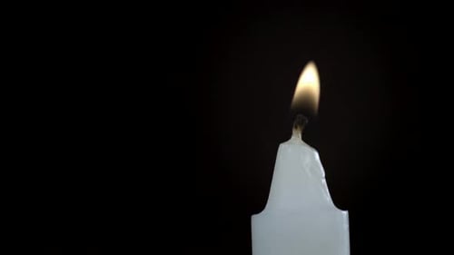 Burning White Candle Extinguished Against Black Background