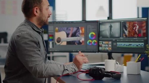 Video Editor Working at Dual Monitor Workstation