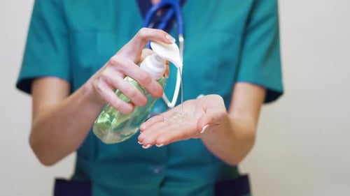 Sanitizing Hands with Green Scrub Shirt
