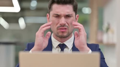 Close Up of Businessman with Laptop Having Headache