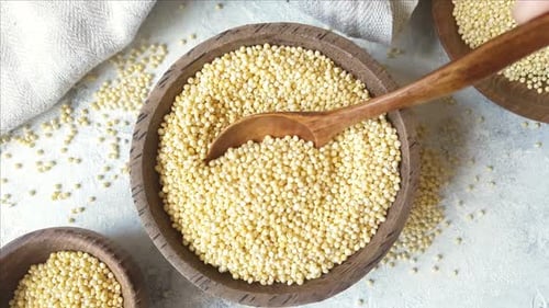 Millet Grain in Wooden Bowl with Spoon