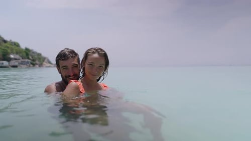 Couple Swimming Together in Tropical Ocean Water