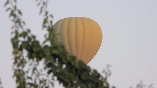 Yellow Hot Air Balloon Gliding Through Sky