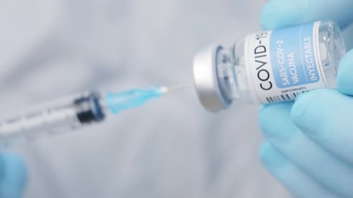 Crop doctor filling syringe with drug in hospital