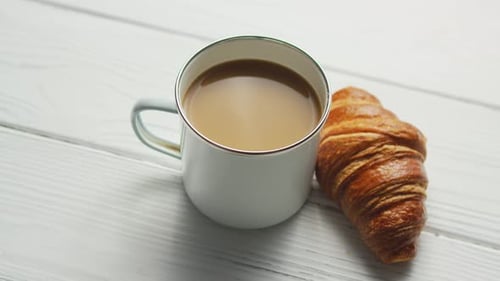 Coffee and Croissant on White Wooden Table