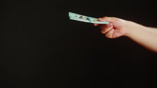 Hands Exchanging Stack of United States Currency