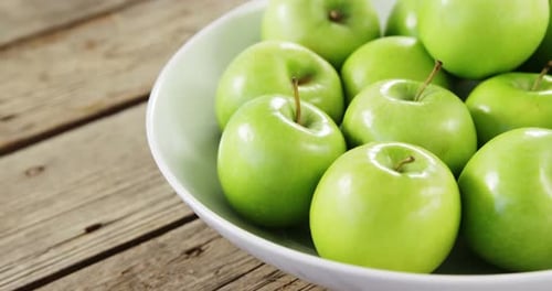 Green apples arranged in bowl