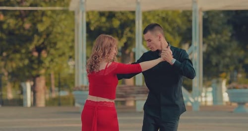 Beautiful Couple Dancing Tango in the Park. Young Woman with an Elegant Man Is Passionately Dancing