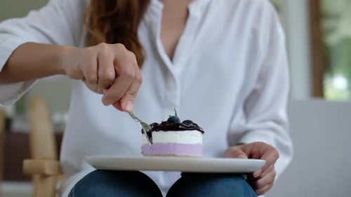 Woman Eats Slice of Cake with a Fork
