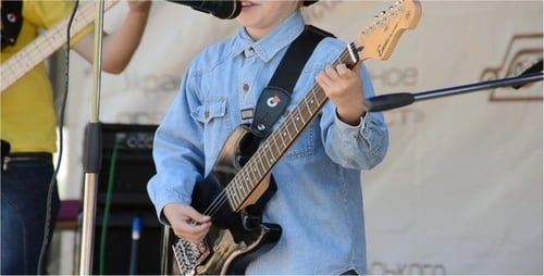 Young Boy Playing Electric Guitar on Stage