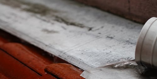 Water Flowing from Drainage Pipe onto Urban Roof