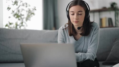 Young Woman Working at Computer with Headset