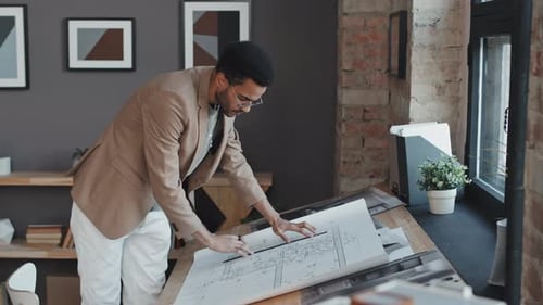 Architect Drawing Blueprints in Office Workplace