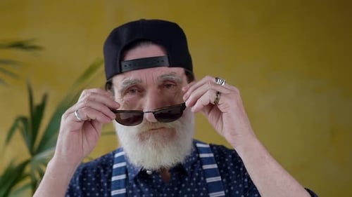Senior Man Puts on Sunglasses and Smiles