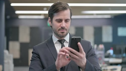 Man Using Mobile Phone in Modern Office