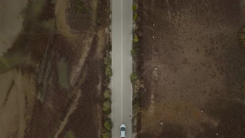 Aerial view of a car driving on asphalt road in Greece.
