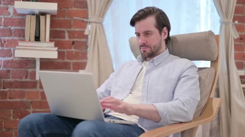 Man Working on Laptop in Comfortable Chair