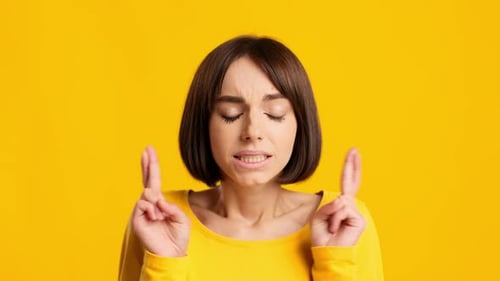 Woman Crossing Fingers and Hoping for the Best