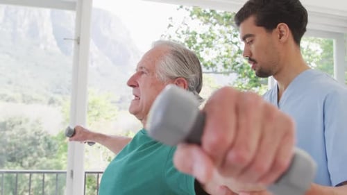 Senior Man Lifts Weights With Medical Assistant