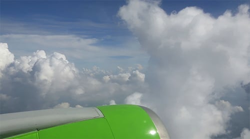 Airplane Wing View Above the Clouds in Daytime