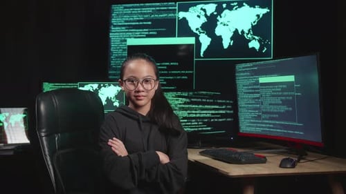 Asian Young Girl Hacker Hacking With Multiple Computer Screens And Pose With With Arms Crossed