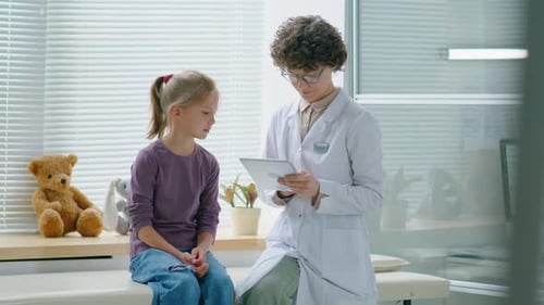 Girl Talking With Doctor in Examination Room