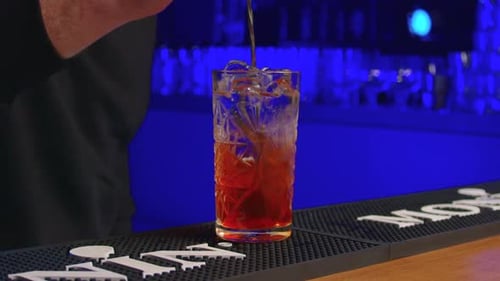 Bartender Stirring a Red Cocktail with Ice