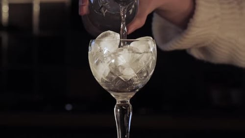 Clear Liquid Poured into Ice-Filled Crystal Glass