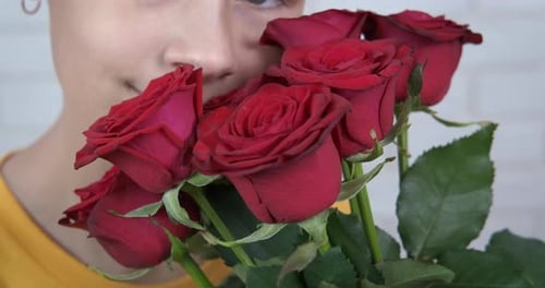 Girl Smells Bouquet of Beautiful Red Roses
