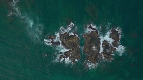 Waves Crash Against Rocks in the Ocean