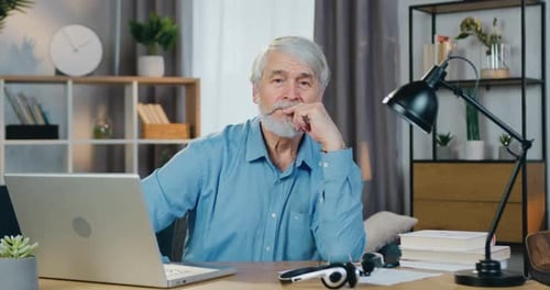 Mature Man Sitting at Desk with Laptop