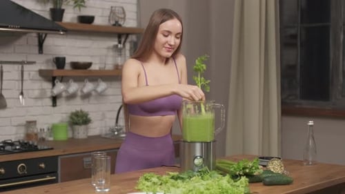 Sporty Woman making, pouring, drinking green vegetable smoothie with blender.