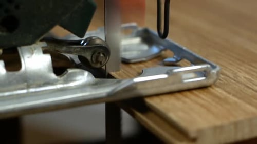 Carpenter cuts a wooden board with an electric jigsaw.Worker close-up of a jigsaw. DIY interior