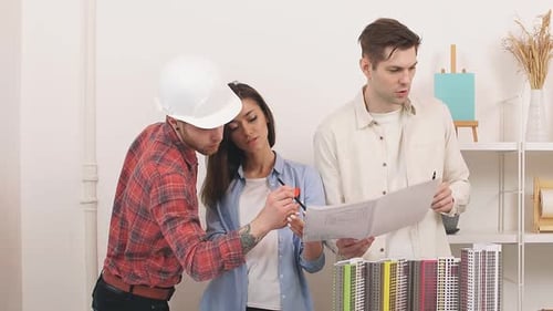 Architects Reviewing Blueprints with Building Model