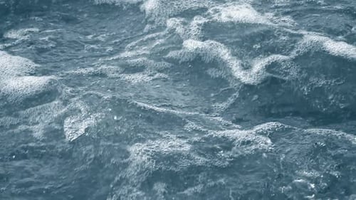 Turbulent Ocean Water with White Foam on Surface