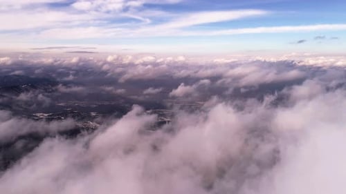 Aerial View of Mountains Through Clouds