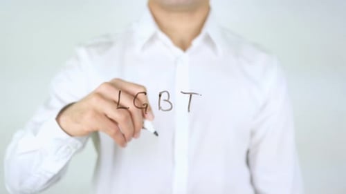Man Writing 'LGBT' with Marker on Glass