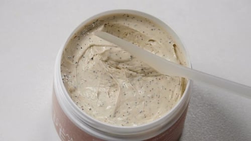 Scrub Cream Scooped from Container with Applicator